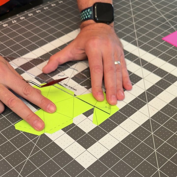 Scoring the fold lines with a dry pen along a ruler.